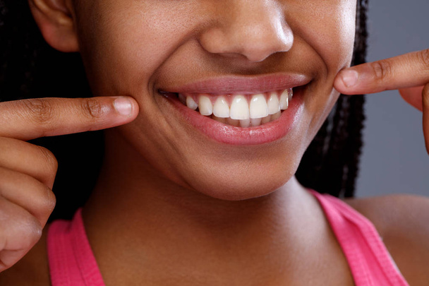 Afrikanerin zeigt auf ihre Zähne, Nahaufnahme - Foto, Bild