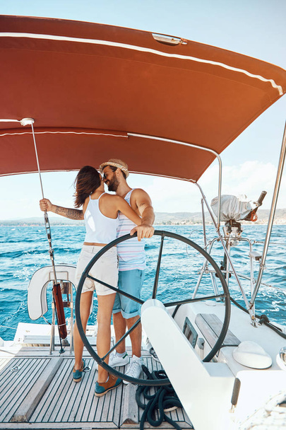 Beautiful man and woman of lovers sailing on a boat - Foto, imagen