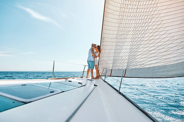Young man and woman in love sailing sailboat yacht - Фото, изображение