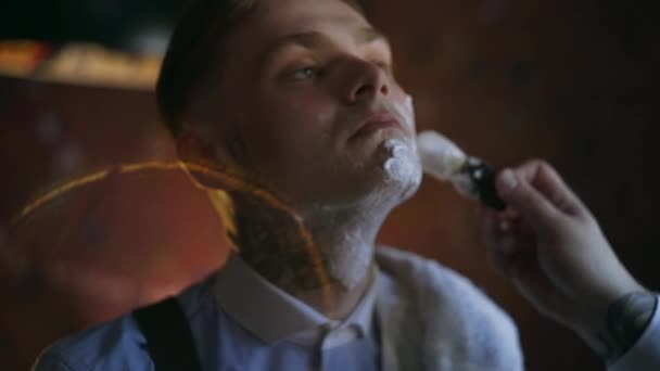 Barbeiro tatuado aplica espuma por escova de barbear no rosto de seu cliente tatuado, barbearia no estilo da máfia dos anos 30, salão de barbear, 4k UHD 60p Prores HQ 422
 - Filmagem, Vídeo