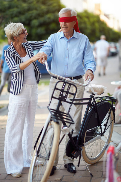 senior woman buying new bicycle for surprise - Foto, afbeelding