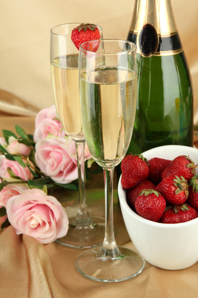 Romantic still life with champagne, strawberry and pink roses, on color fabric background - Foto, imagen