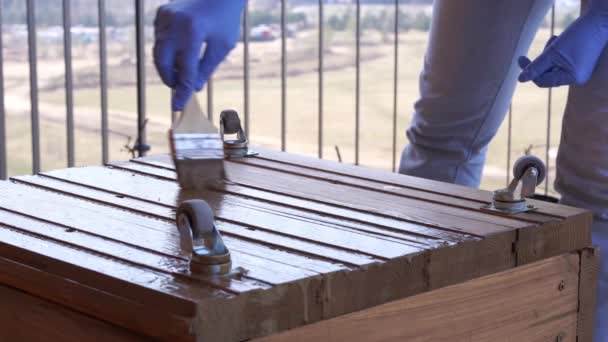 ガーデニングと園芸 - テラスの女性は、クローズアップを植えるために木箱を塗装しています - 映像、動画