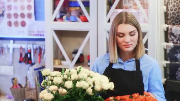 Mujer joven florista está hablando con el cliente
 - Imágenes, Vídeo