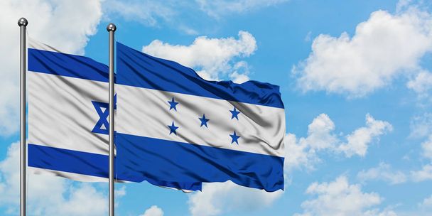 Israel and Honduras flag waving in the wind against white cloudy blue sky together. Diplomacy concept, international relations. - 写真・画像