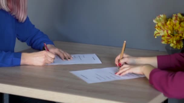 Hands of two businesswoman while signing contracts. Two woman shaking hands in office - Séquence, vidéo