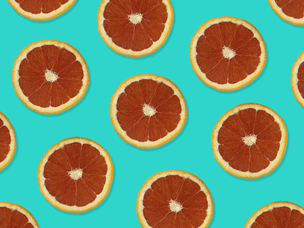 Patrón creativo hecho de naranjas rojas. vista superior del patrón de fruta colorida de rodajas de naranja roja fresca sobre fondo colorido púrpura
.  - Foto, Imagen