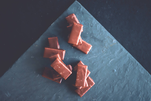 süße Schweizer Schokoladenbonbons auf einer Steinplatte, flach - Foto, Bild