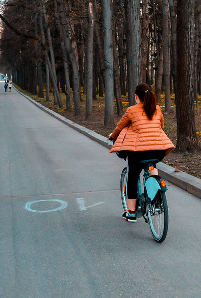 Girl rides a bike through the spring park - Foto, Imagem