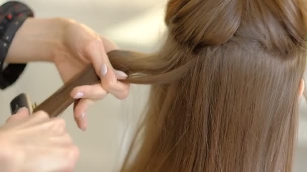 Egy nő fodrász csinál egy terjedelmes frizura, hogy az ügyfél segítségével a haj ironer, préseléséhez haj. Professzionális fodrász a munkahelyen. lassított mozgás - Felvétel, videó