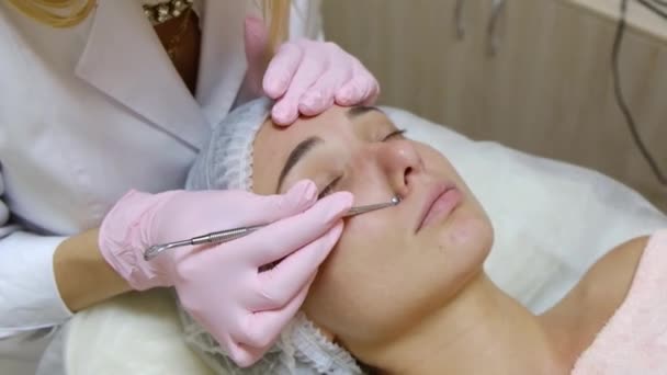 Procedimento para limpar a pele do rosto com um aparelho de aço com uma colher de cravos e acne. - Filmagem, Vídeo