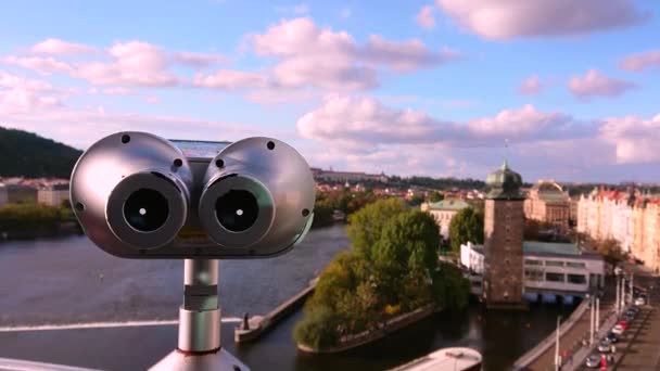 A hand appears in the frame, grabs the binoculars, which stands on the roof of the dancing house, which is aimed at the panorama of the city and the camera is coming close to the lens of the - Footage, Video