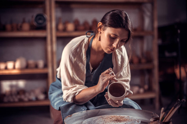 Чарівна учениця-гончарка працює з глиною на гончарному колесі. Реставрація забутих керамічних традицій
. - Фото, зображення