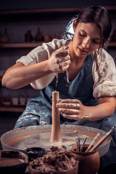 スタイリッシュな陶芸家が、粘土や陶器の車輪を使って作業する方法を示しています。インスピレーションと創造性. - 写真・画像