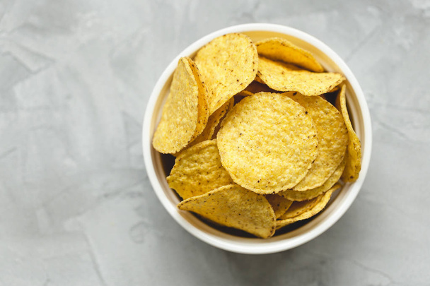 Tortilla chips de milho em tigela um fundo cinza
 - Foto, Imagem
