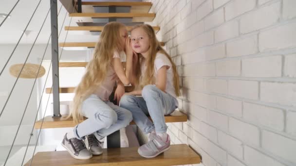 Twins gossiping on steps at home - Felvétel, videó