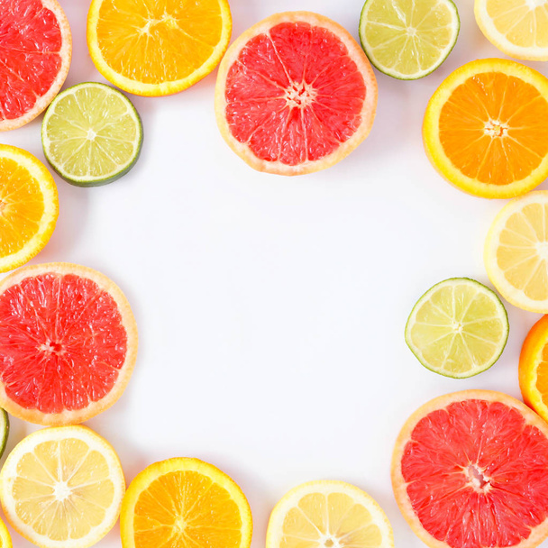 新鮮な柑橘系のスライスのカラフルなフルーツ正方形のフレーム。上のビュー、フラットは、コピースペースを持つ白い背景の上に横たわっています. - 写真・画像