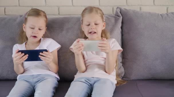 Twins using smatphones on sofa - Filmagem, Vídeo