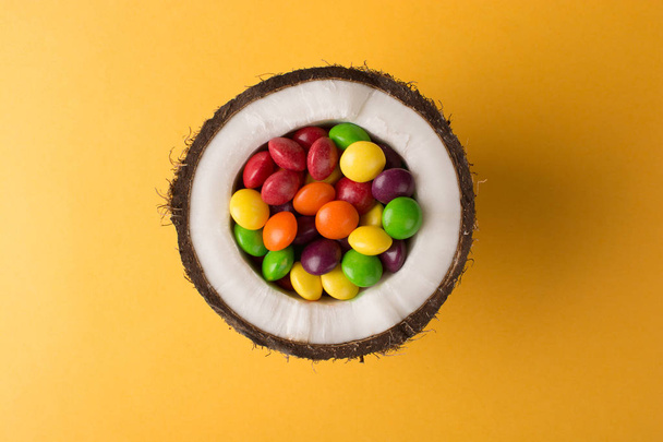 Coconut with colorful candies. - Photo, image