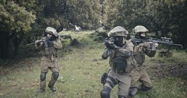 Squad van volledig bewapende commando soldaten tijdens gevechten in een boslandschap - Video