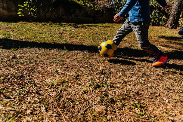 Les enfants courent après un vieux ballon de foot dans un match amical en summe
 - Photo, image