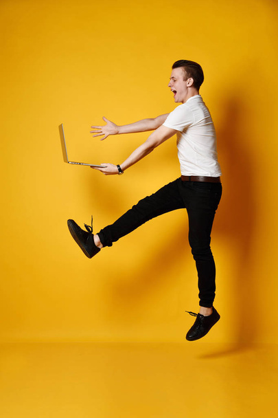 Jumping student with laptop - Φωτογραφία, εικόνα