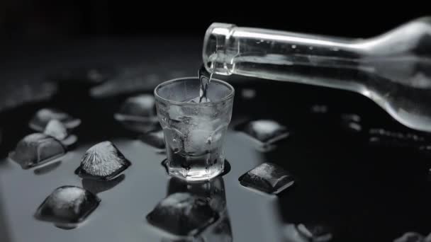 A despejar uma dose de vodka em vidro. Fundo preto. Despeje de bebida alcoólica
 - Filmagem, Vídeo