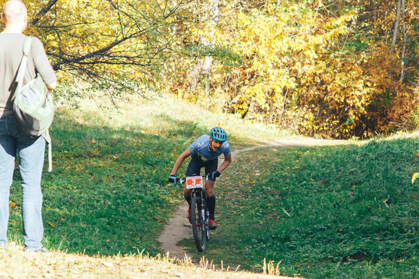 14. Oktober 2018, Minsk, Weißrussland.2018 Olympischer Cross Country Cup XCO in Medvezhino Radler auf dem Fahrrad entlang der Strecke im wunderschönen Herbstwald - Foto, Bild