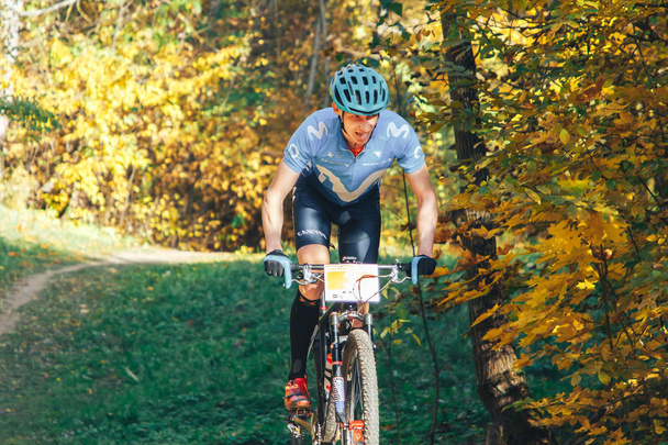 October 14, 2018, Minsk, Belarus.2018 Olympic Cross Country Cup XCO in Medvezhino Cyclist on the bike along the trail in the beautiful autumn forest - Foto, imagen