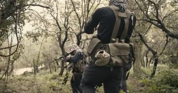 Bewaffnete Terroristen patrouillieren während des Kampfes in einem Waldgebiet - Filmmaterial, Video