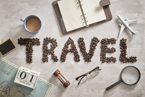Cosas esenciales para el viajero con carta de viaje de grano de café en el suelo
 - Foto, Imagen