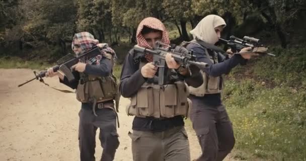 Skupina ozbrojených teroristů hlídaná v lesní oblasti během boje - Záběry, video