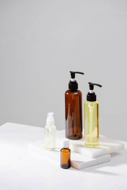 Spa cosmetics in brown glass bottles on gray concrete table. Copy space for text. Beauty blogger, salon therapy, branding mockup, minimalism concept - Photo, image