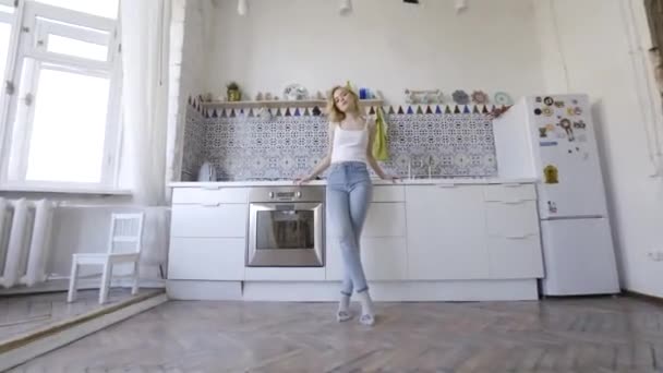 Relaxed sexy blonde posing on kitchen in morning. Action. Sexy young blonde woman in the kitchen at home - Footage, Video