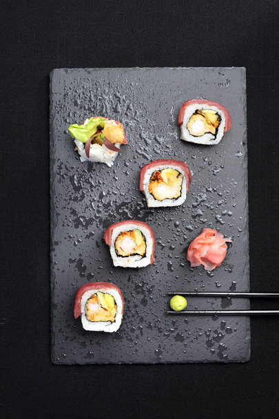 Sushi with avocado shrimp and salmon. Set on a black background - Zdjęcie, obraz