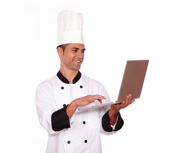 Handsome male in chef uniform working on computer - Foto, afbeelding