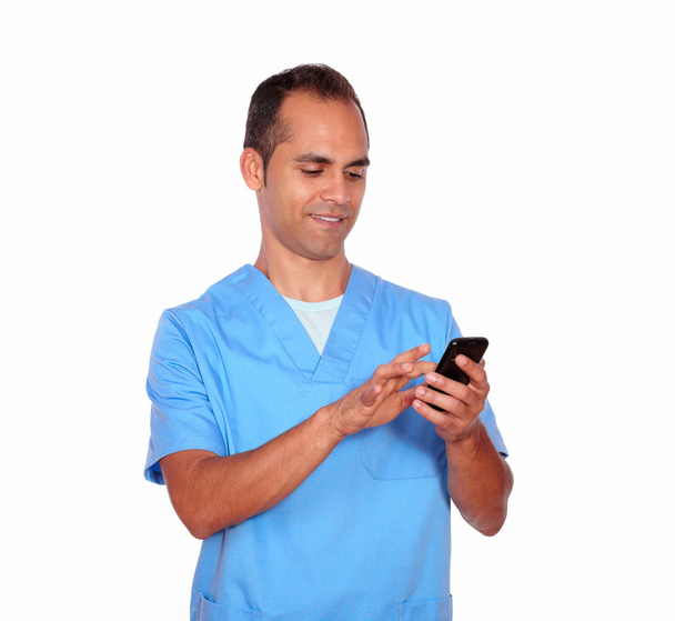 Smiling boy nurse sending message on cellphone - Foto, Bild