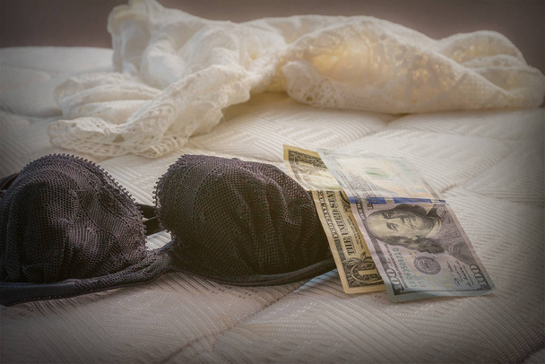 Reggiseno di prostitute sul divano con i suoi denaro.Concetto di prostituzione
 - Foto, immagini