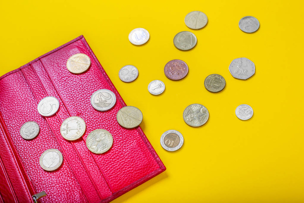 Відкрити жіночий червоний шкіряний гаманець з різними монетами на жовтому тлі
 - Фото, зображення
