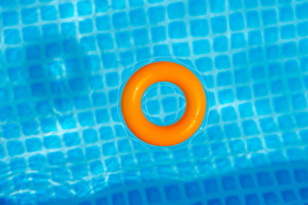 pomarańczowy nadmuchiwane pierścień pływające w basenie w słoneczny dzień, widok z góry - Zdjęcie, obraz
