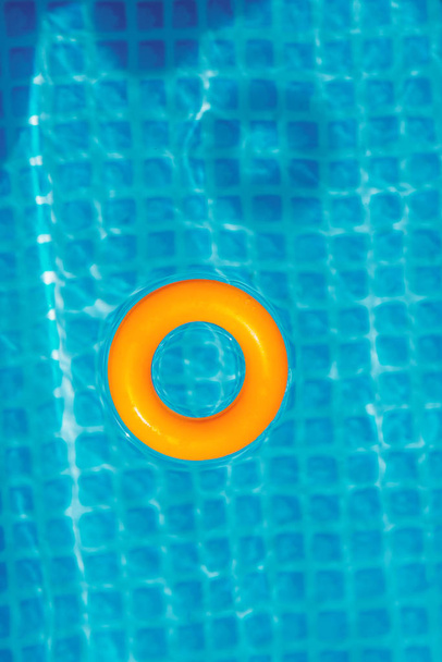 yellow Inflatable ring floating in swimming pool on sunny day, top view - Photo, Image