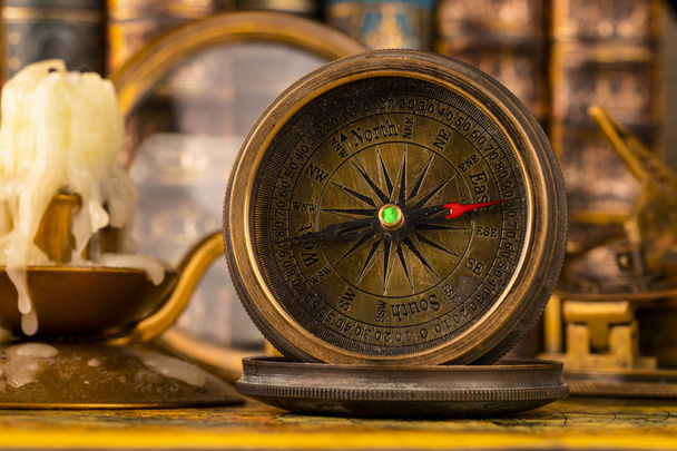 Antique compass on the background of the magnifying and books. V - Photo, image
