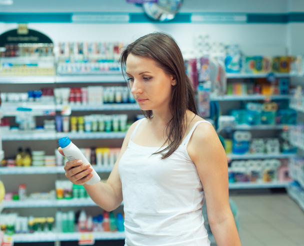 junge Frau beim Einkaufen im Geschäft Haushaltschemikalien und Kosmetik - Foto, Bild