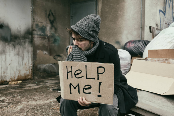 Poor young man with HELP ME sign at dump - Фото, зображення