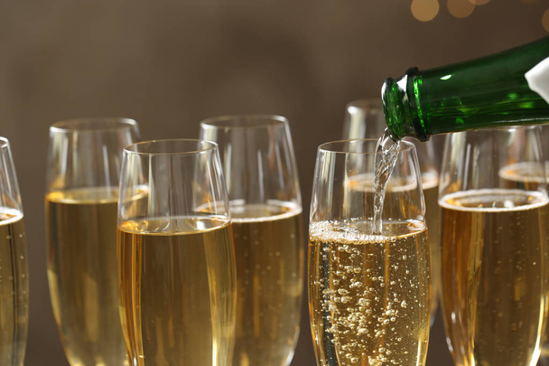 Pouring champagne into glasses on blurred background, closeup - Photo, Image