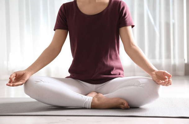Donna che pratica yoga sul pavimento al chiuso, primo piano
 - Foto, immagini