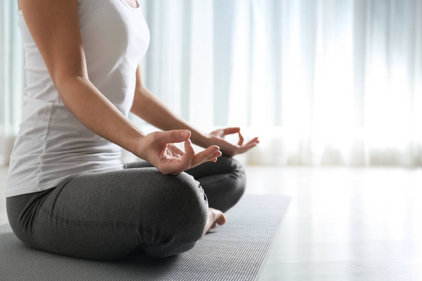 Woman practicing yoga on floor indoors, closeup. Space for text - Photo, Image