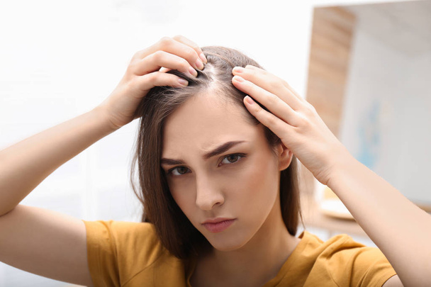 Mujer joven con problemas de pérdida de cabello en interiores
 - Foto, imagen