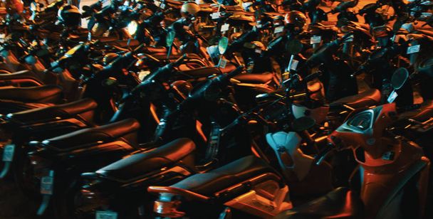 scooters estacionados en filas densas, hermosa iluminación nocturna, enfoque suave, fondo
 - Foto, Imagen