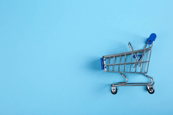 Empty shopping trolley on color background, top view. Space for text - Photo, Image